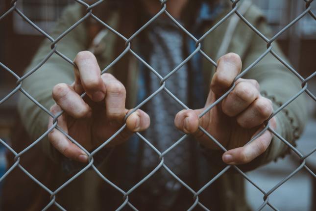Photo: Hands holding a fence