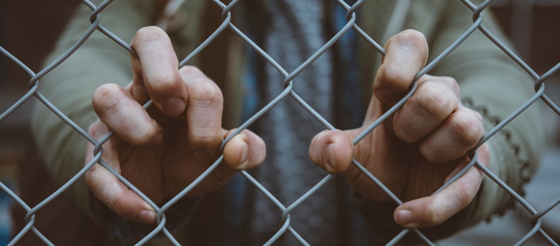 Photo: Hands holding a fence
